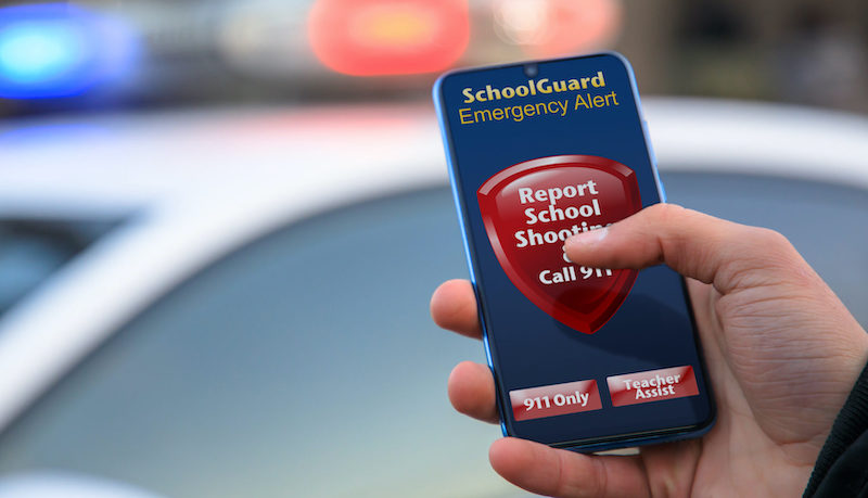 man holding smartphone with SchoolGuard panic button app ready to push
